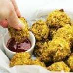 baked veggie balls in basket being dipped into sauce