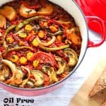 oil free Briam roasted veggie casserole in red pot with lid and recipe title in black text.