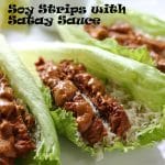 Soy strips with satay sauce on lettuce leaves with cumin-lime cauliflower rice on white plate and recipe label in black text on picture.