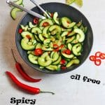 Spicy cucumber salad overhead with limes, red chilis and cucumber slices with recipe name in black text at bottom