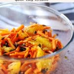 carrot orange cumin pepita slaw in glass bowl with text overlay with recipe title and website.