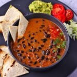 Chipotle black beans in coconut milk sauce with text overlay with recipe title