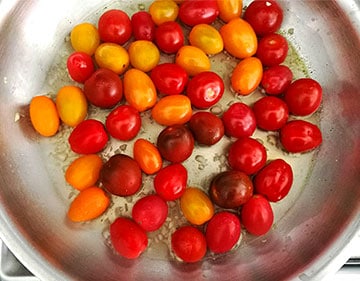 Fresh cherry tomatoes, yellow, red and orange in skillet