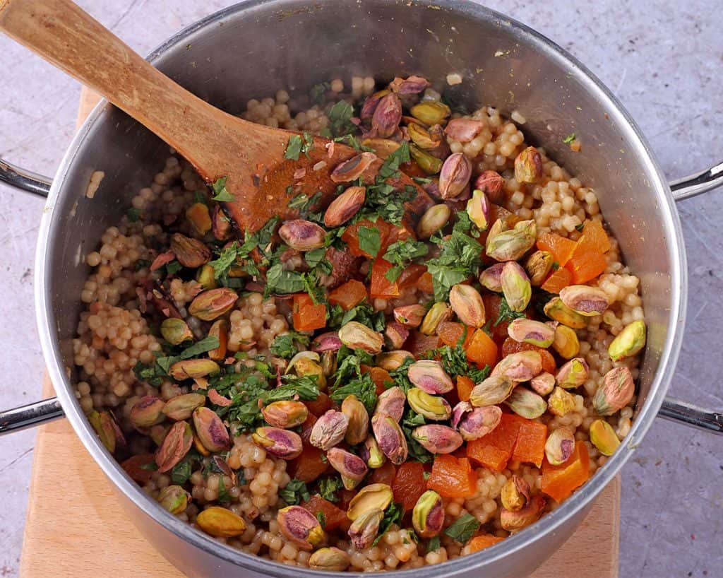 Cooked pearl couscous with diced dried apricots, pistachios, and chopped fresh mint