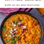 sweet potato dahl with red lentils in black bowl overhead with coriander, diced red onions and red chili on top and text overlay with recipe title.