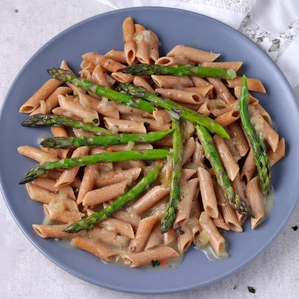 Blue plate with with asparagus tips and whole wheat pasta with tarragon sauce