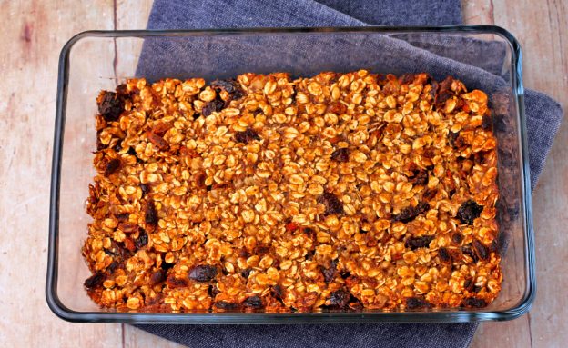 baked granola bars with oats, dried cranberries, and Goji beans in glass baking dish