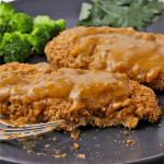 Chickpea cutlets are smothered in mustard sauce and cut with a fork.
