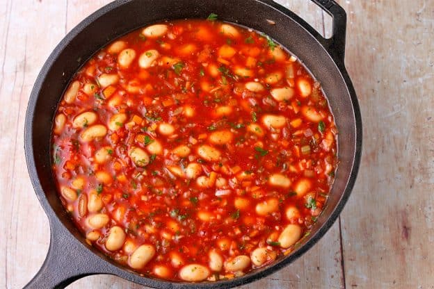 Gigantes Plaki with Gigantes beans are placed in a baking pot with tomato sauce.