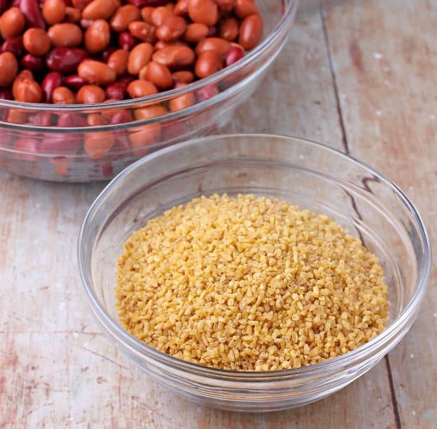 A glass bowl is filled with dry bulgur.
