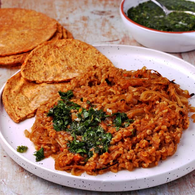 A white plate with Lebanese mujadara recipe with red lentils and bulgur.