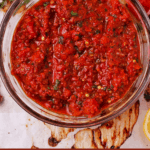 An overhead shot of a bowl of red pepper harissa paste.