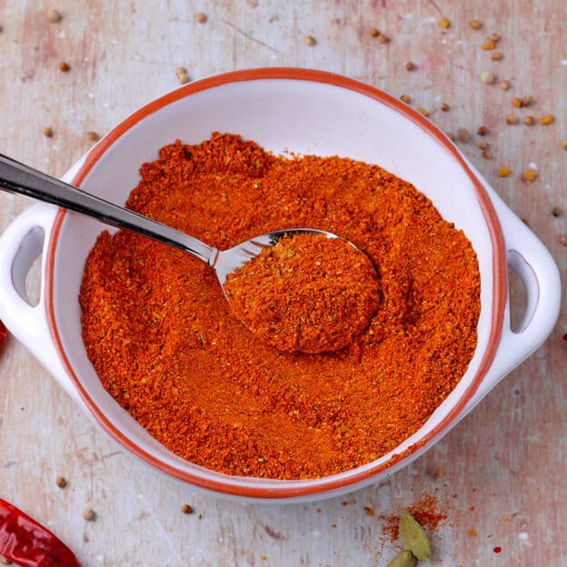 Berbere spice mix in a bowl with a spoon.