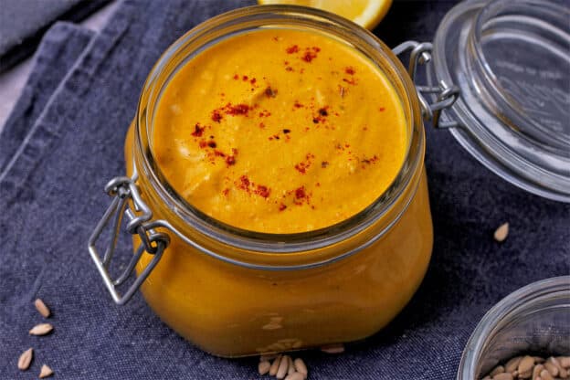 A jar is filled with curry dipping sauce.