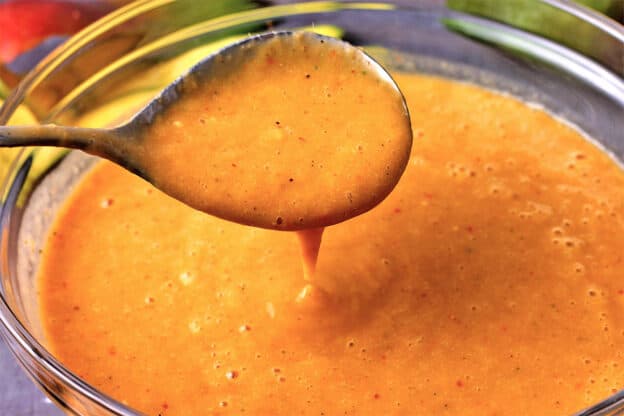mango curry sauce in a bowl with a spoon.