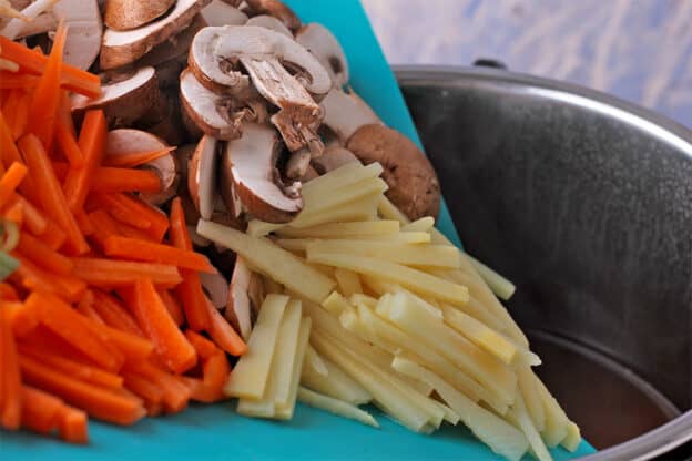 Carrots, bamboo shoots, and mushrooms are added to an Instant Pot.