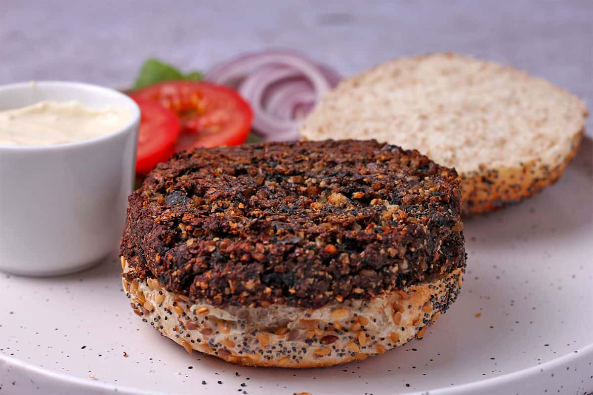 A mushroom burger is placed on an open-faced bun.