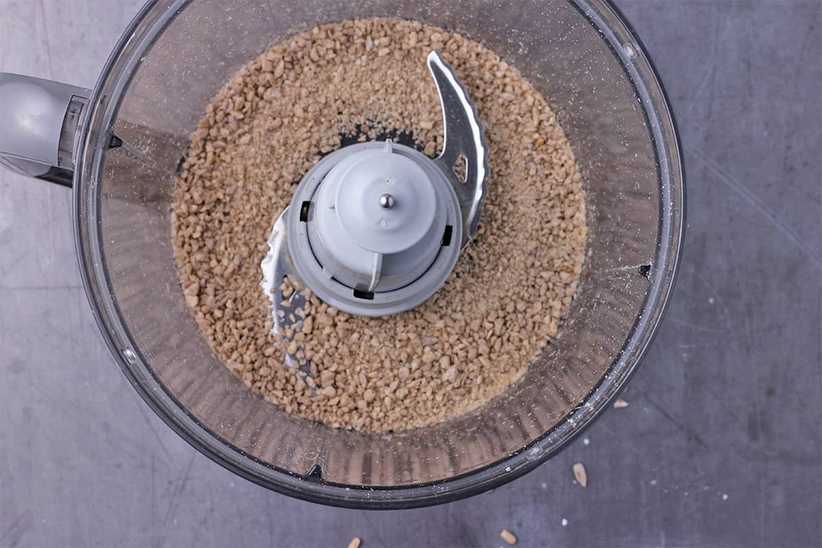 Shelled sunflower seeds are broken down in a food processor.