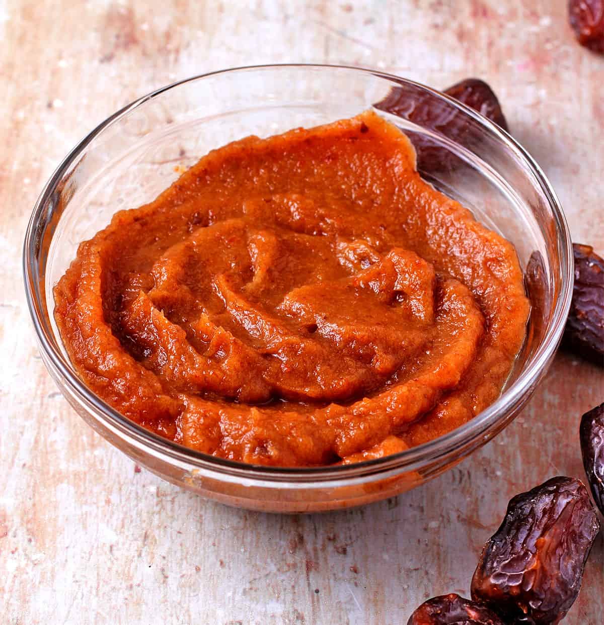 A glass bowl of homemade date paste.
